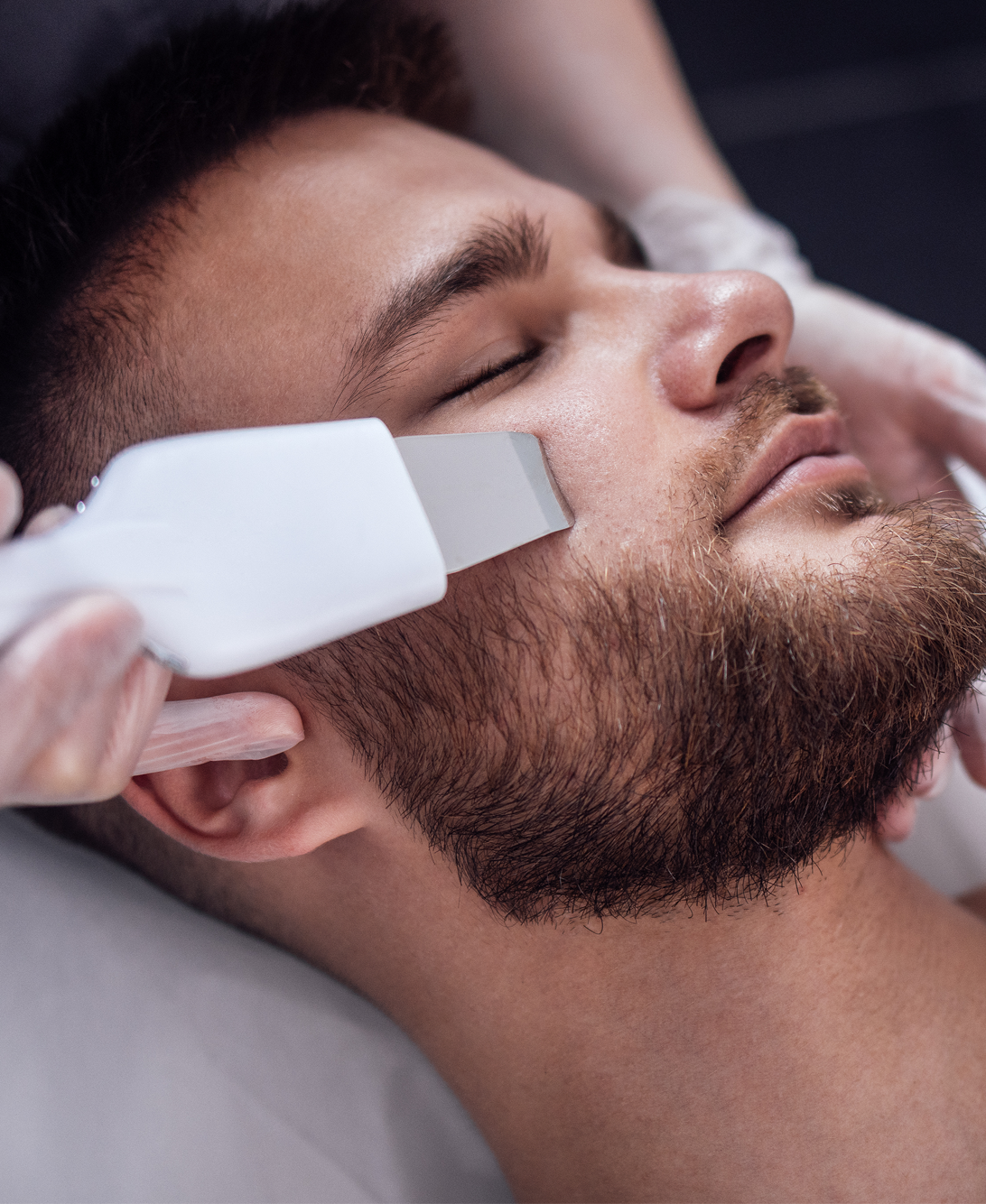 younger man getting facial treatment