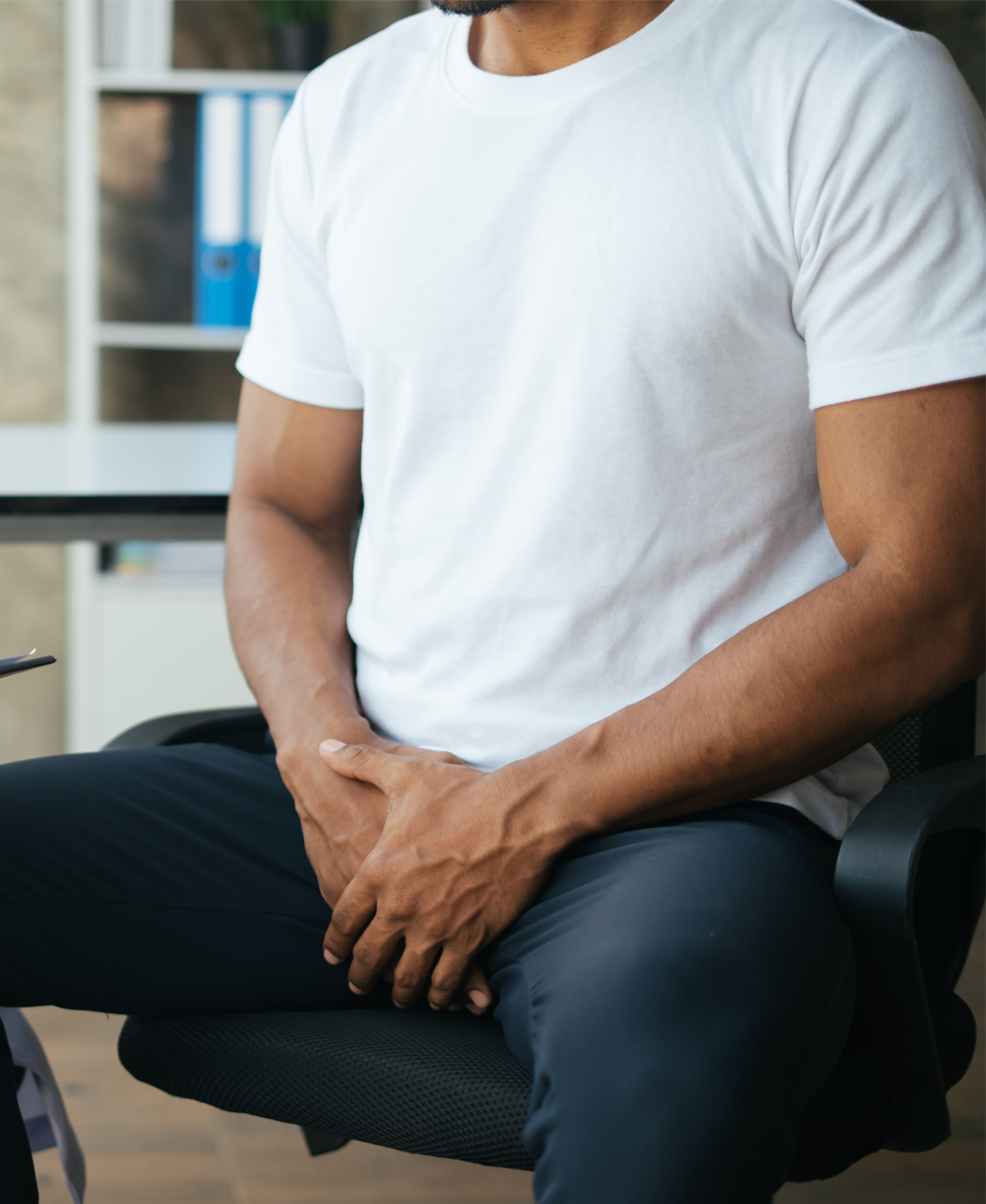 man sitting in chair with pelvic floor issue